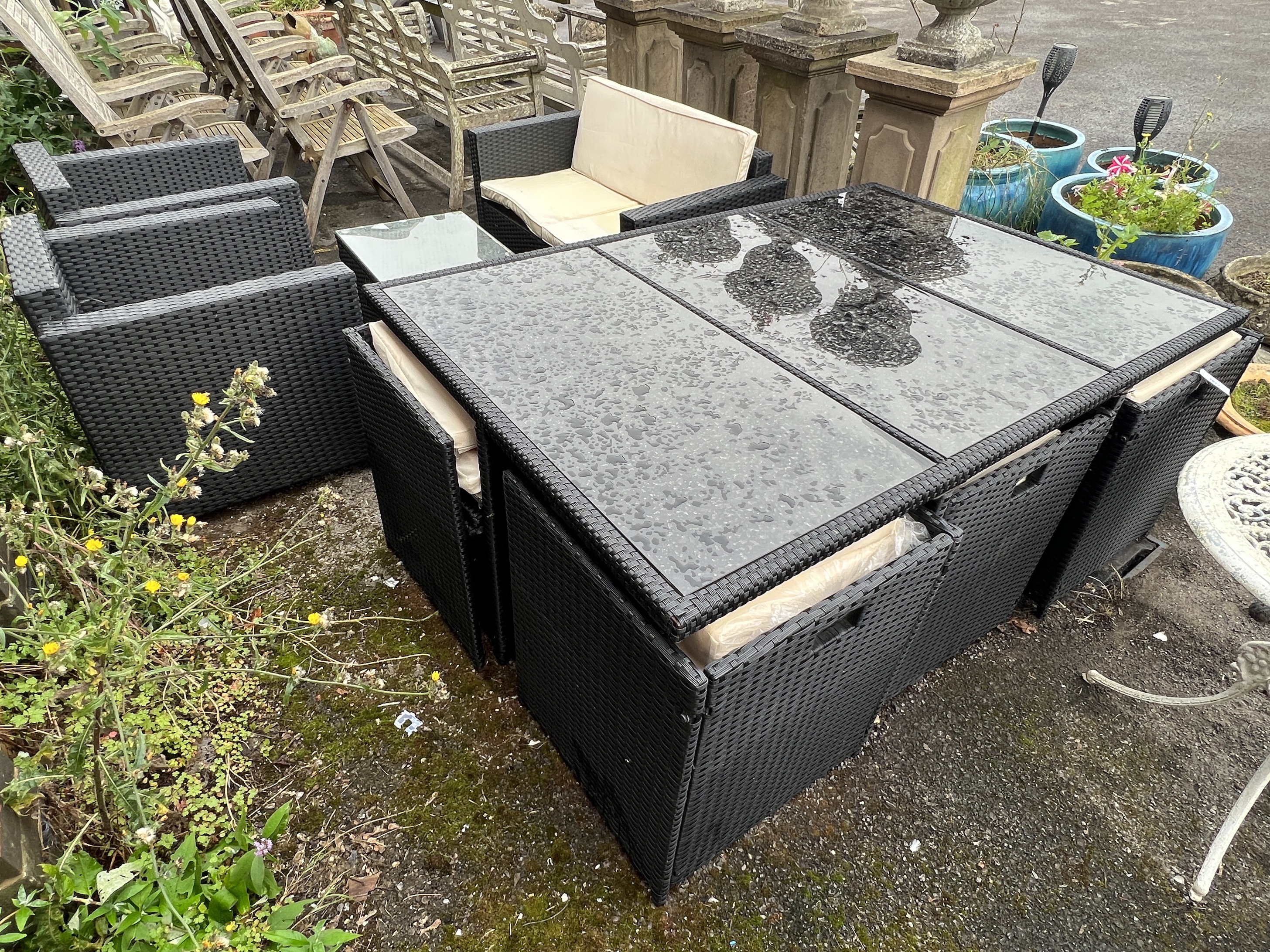 A black all weather rattan rectangular garden table and chair set, width 166cm, depth 109cm, height 67cm together with a matching three piece garden set with coffee table